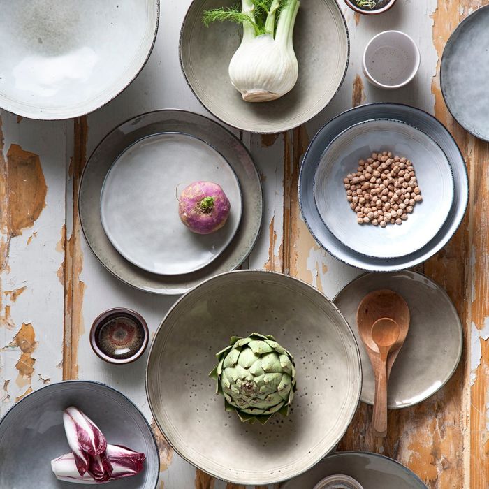 Tabo serien af stentøj med forskellige grøntsager på et afskallet bord