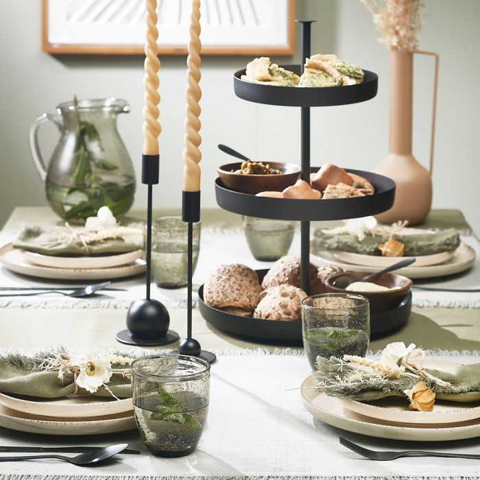 Sort kniv og gaffel ved siden af tallerken med farverig salat