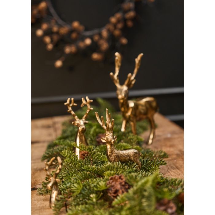 Guldfarvede dyr med gran og kogler på bord.