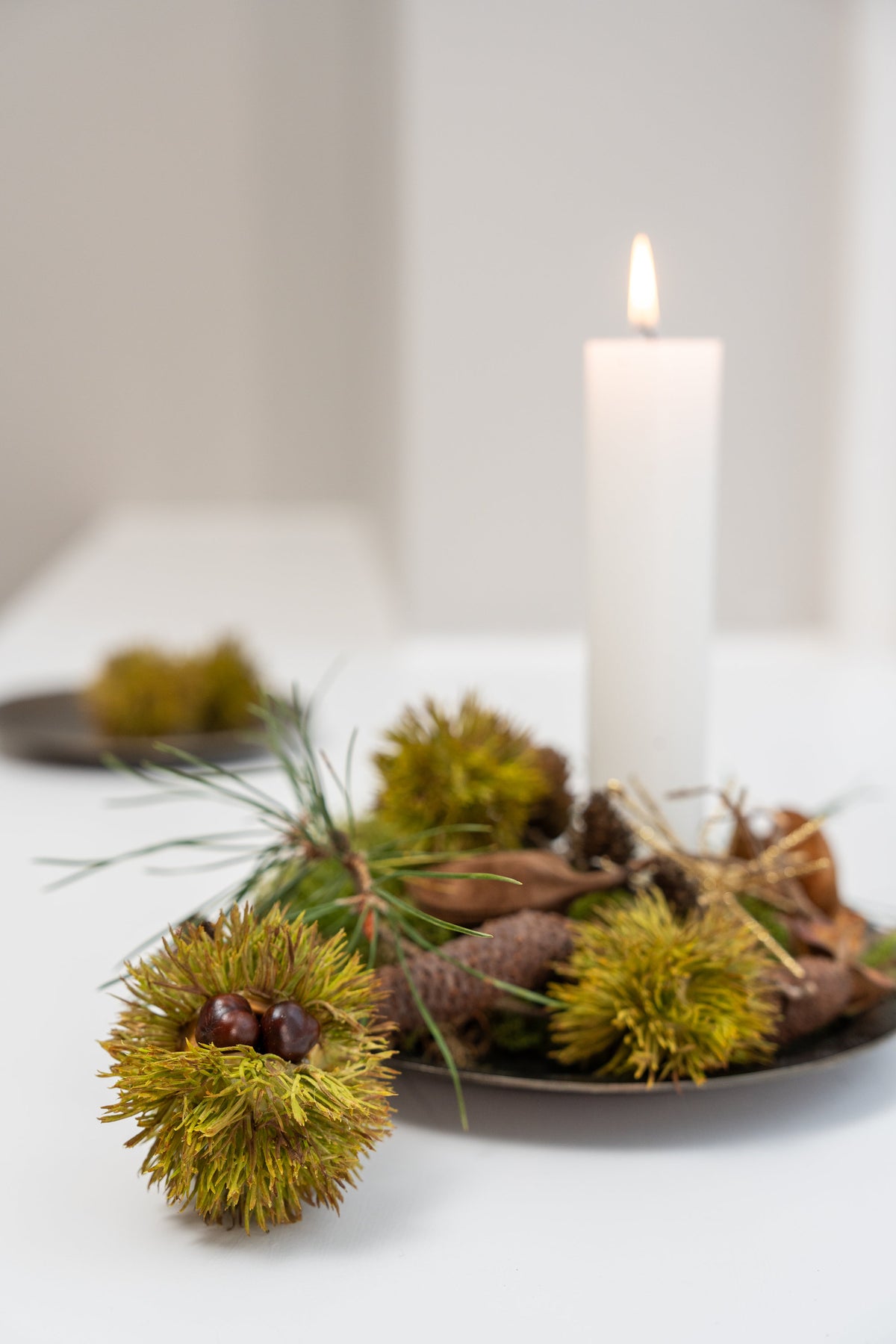 Juledekoration på metalbakke med kunstige kastanjer og kogler