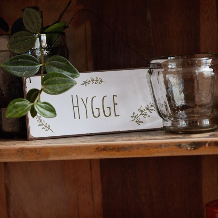 Metalskilt "Hygge" med bladgrene fra Ib Laursen stående på hylde