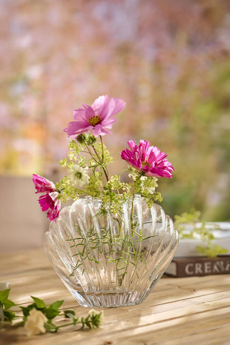 Muslingevase i glas med rosa blomster i