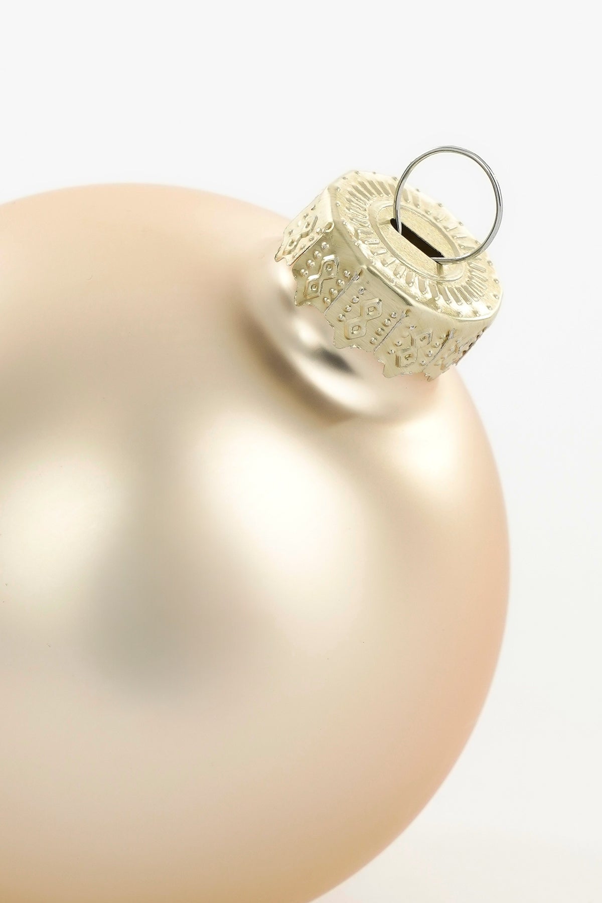 Toppen af mat cremefarvet julekugle i glas
