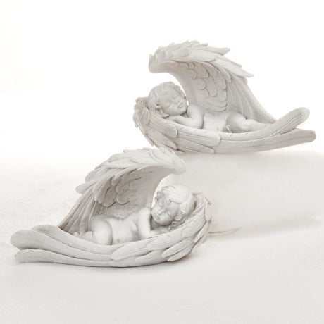 Engel ligger hvilende i sin egen englevinger, som vuggende i en båd. Englene findes i to udgaver, hvor spidsen af vingerne vender hver sin vej, begge i hvid. Fra Pobra. 