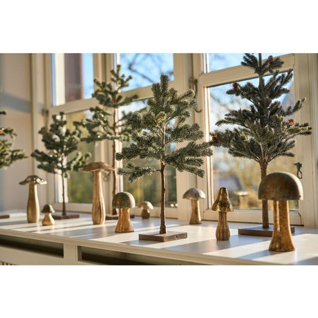 Svampe i træ og metal sammen med opstammede grantræer til dekoration.