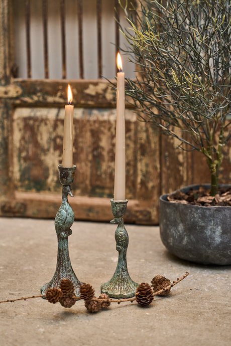 Påfugleformede lysestager med lys i og lille lærkegren foran