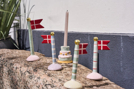 Flag i keramik står på en stenflade sammen med en kertelysetage