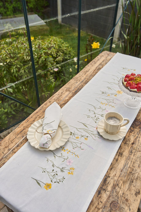 Bord med bordløber og stofserviet på tallerken