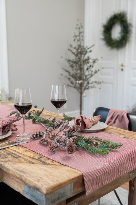 Kunstig koglegrene brugt liggende som bordpynt på julebordet