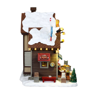 The Cocoa Shanty hus med lys til juleby fra Lemax set fra siden med lille bænk
