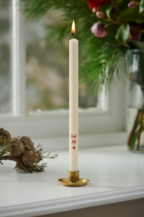 Kertelys med God Jul i guldfarvet stage i vindueskarm