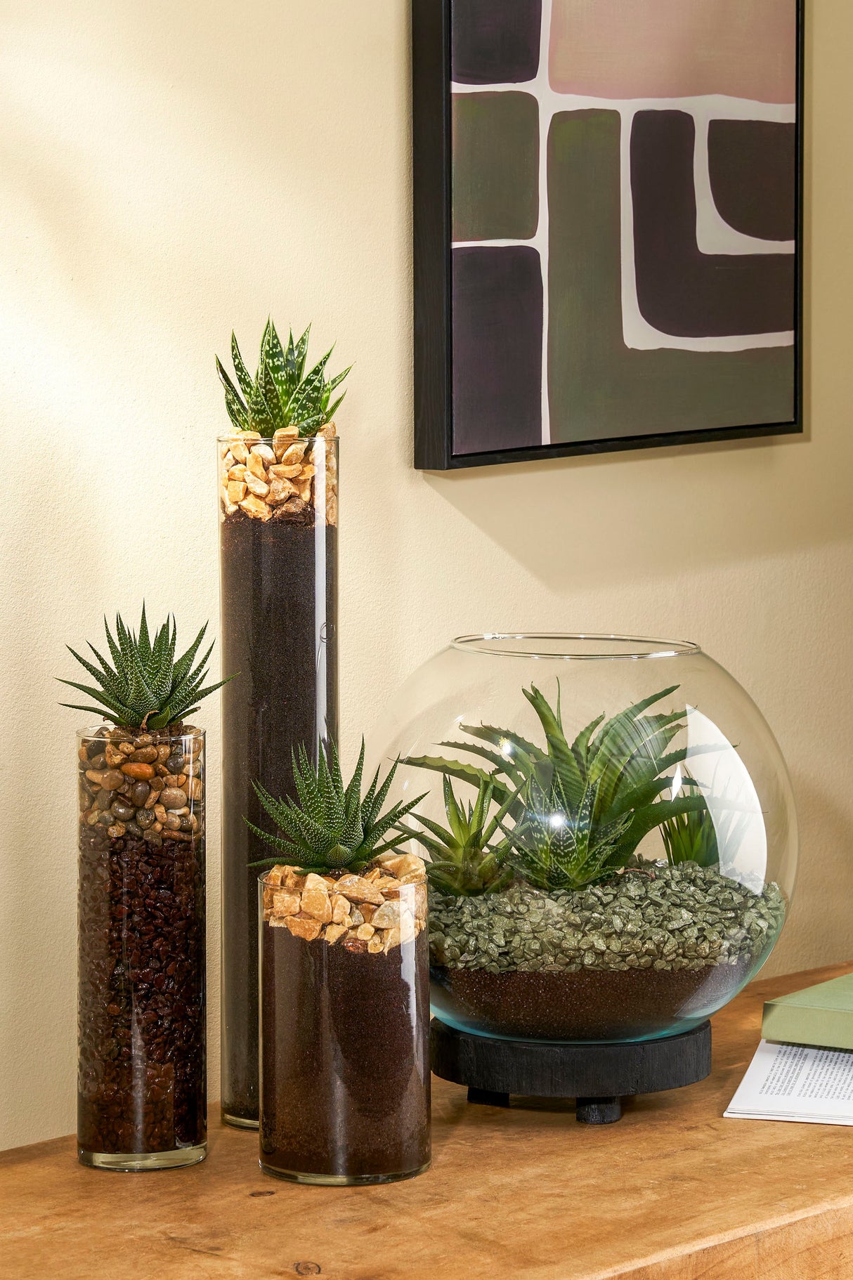 Cylinderglas og glasbowle med dekorationssten og planter i