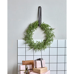 Krans med thuja kunstgran fra House Doctor hængende med bredt velourbånd på væg