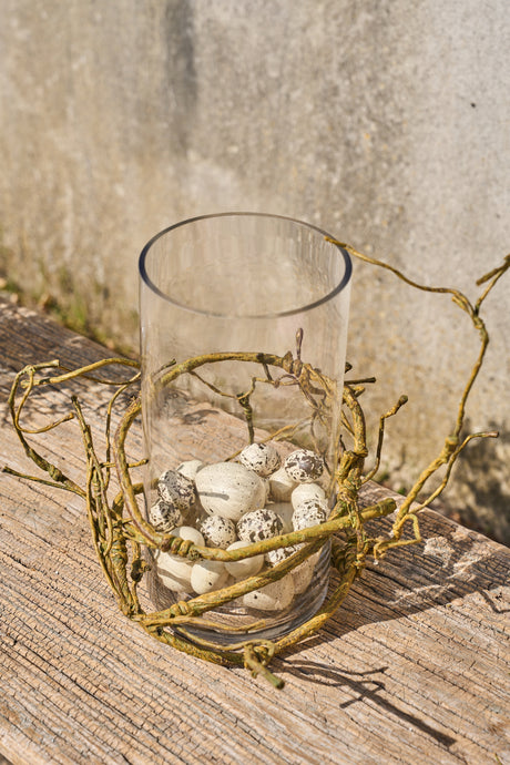 Kunstige påskeæg i cylinderglas med grene rundt om