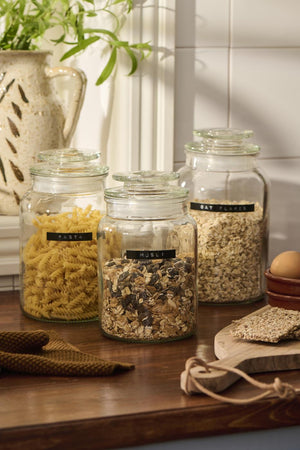 Tre opbevaringsglas fra Ib Laursen med forskellige tørvarer på et træbord