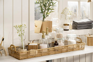 Sæbedispenser i glas fra Ib Laursen på en bakke med badeværelsestilbehør og grønne planter