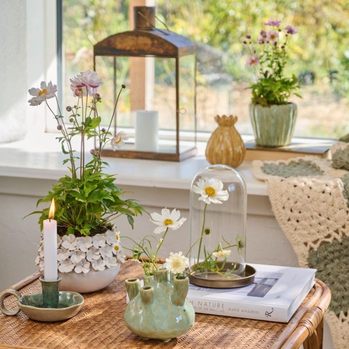 Ib Laursen Glasklokke Bornholm 20 cm med hvid og gul blomst på lille bord