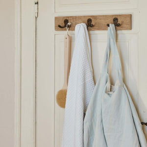 Nærbillede af Ib Laursen Unika knagerække med 3 knager på badeværelsesdør med hvidt håndklæde