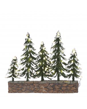 Snowy trees on stone wall with warm white light
